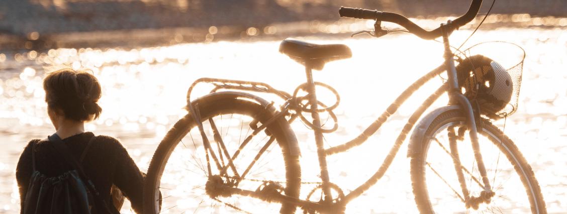 Frau mit Fahrrad am See