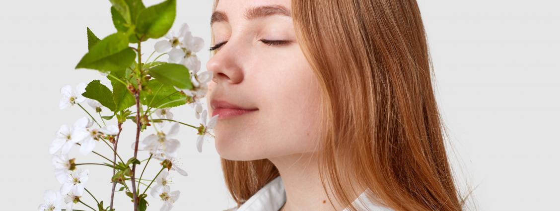 Junge Frau riecht an Kirschblütenzweig 
