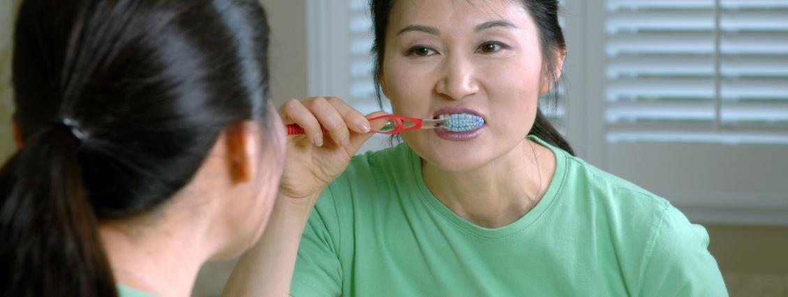 Frau putzt mit Handzahbürste Zähne