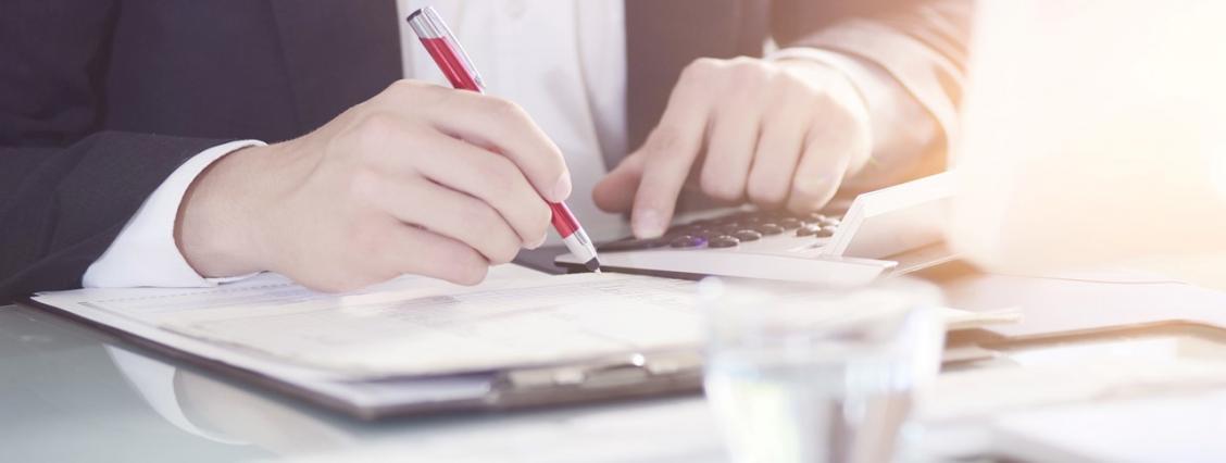 Jemand kalkuliert etwas an einem Schreibtisch